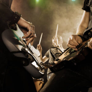 rock band performs on stage. bassist in the foreground. close up.